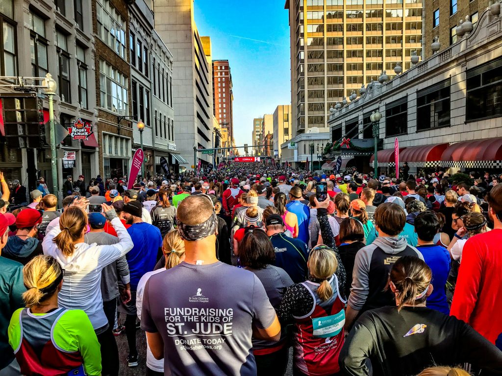 Runners wearing custom 5K race shirts at a charity event start line